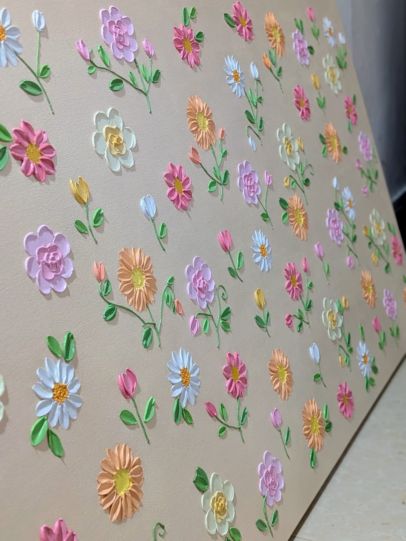 Close-up of sculpted pastel flowers on a textured canvas by Malshi